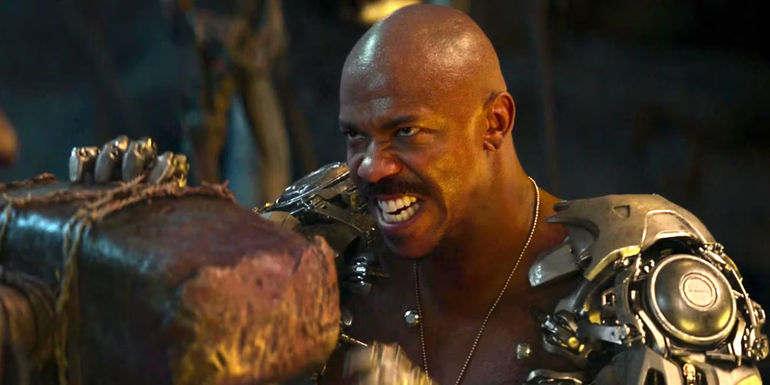 Mehcad Brooks as Jax in Mortal Kombat holding off a blow from a hammer