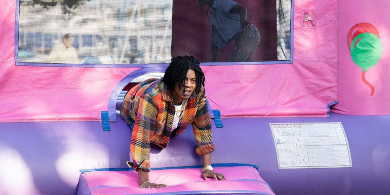 Lamont (RJ Cyler) crawling out of a bouncy castle in Rap Shit.