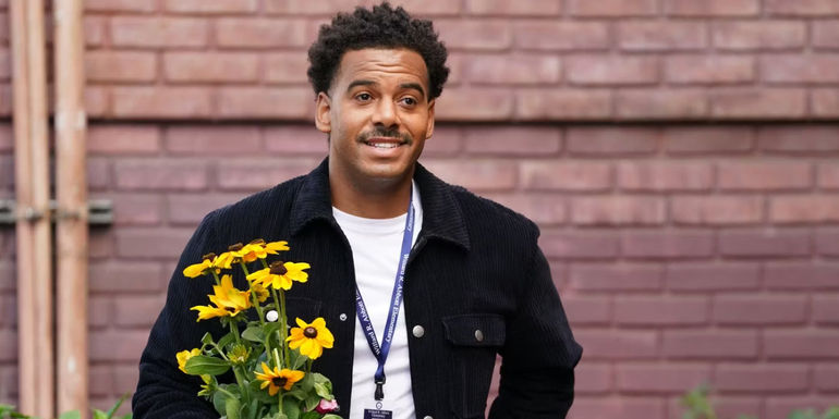 Tariq (Zack Fox) holding flowers and smiling in Abbott Elementary.