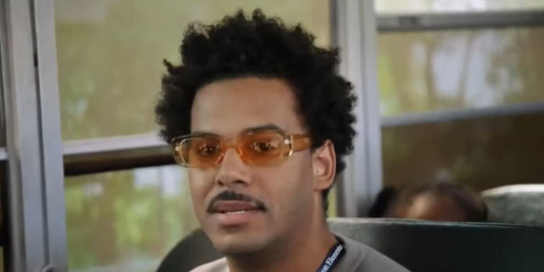 Tariq (Zack Fox) wearing orange sunglasses and staring at the camera in Abbott Elementary.
