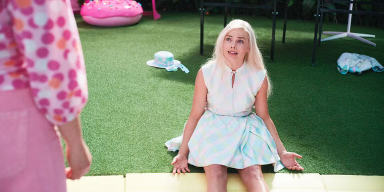 Barbie sitting on the ground with an exasperated look on her face