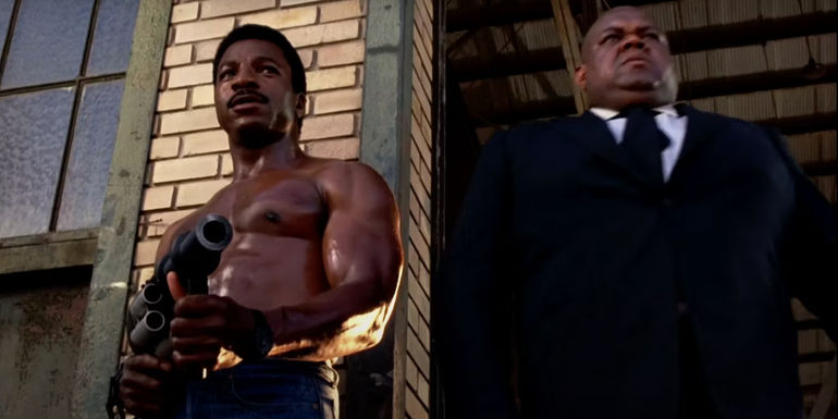 Carl Weathers holding a grenade launcher and Prince A. Hughes as Edd in Action Jackson