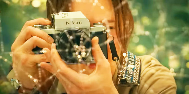 Cassie's mother taking a picture of a spider web in Madame Web