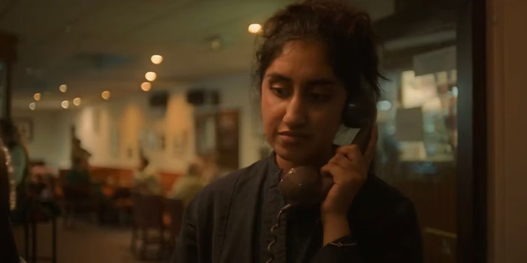 Emma holding a phone up to her ear. 