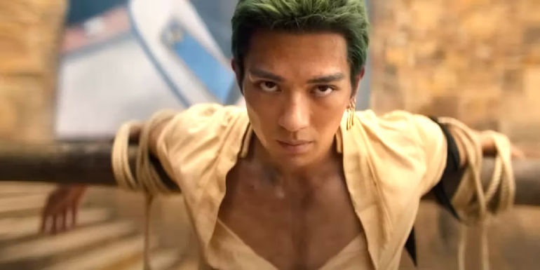 Mackenyu as Zoro tied to a wooden bar in One Piece
