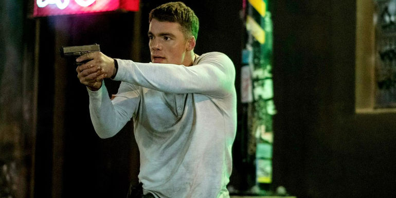 Peter Sutherland pointing a gun in The Night Agent