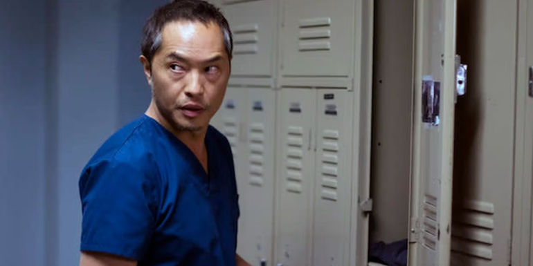 Topher (Ken Leung) opening a locker and looking over his shoulder in The Night Shift.