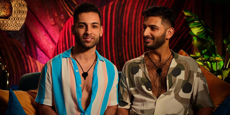 Rehman & Ashmal from Couple To Throuple sitting on a couch and smiling