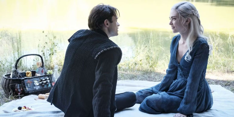 Sebastian (Thomas Doherty) sitting on a picnic blanket with Lizzie (Jenny Boyd) in Legacies.