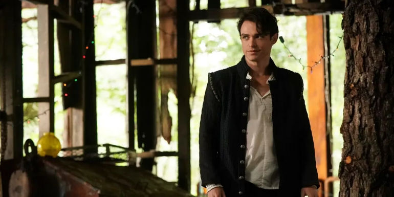 Sebastian (Thomas Doherty) standing and smiling in Legacies.