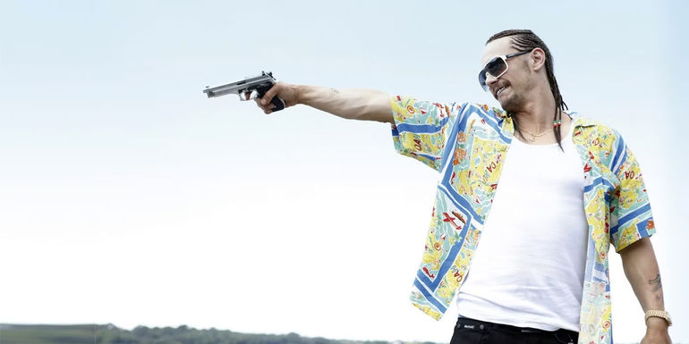 James Franco as Alien shooting a gun in Spring Breakers