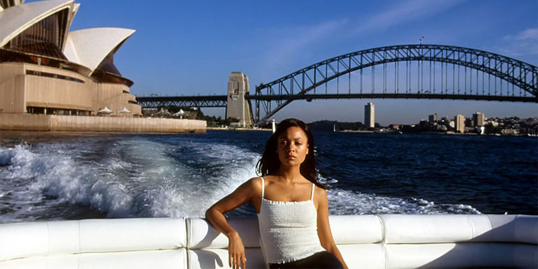 Nyah on a boat with Sydney Australia behind her in Mission: Impossible II