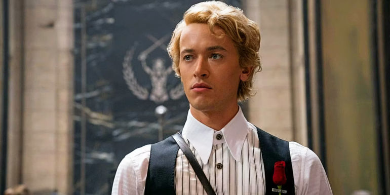 A young Coriolanus Snow (Tom Blyth) with a rose pinned to his vest in The Hunger Games The Ballad of Songbirds and Snakes