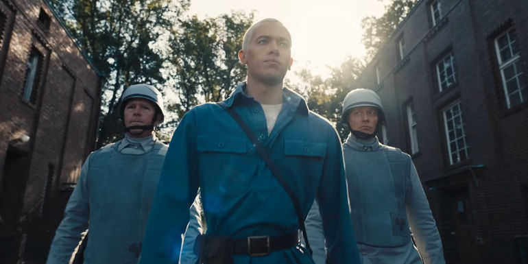 Tom Blyth as Coriolanus Snow walking with Peacekeepers in The Ballad of Songbirds and Snakes