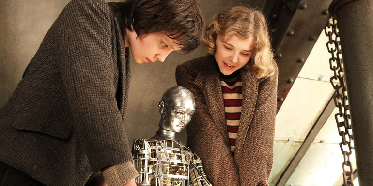 Asa Butterfield and Chloe Grace Moretz looking at a mechanical man in Hugo 2011 movie