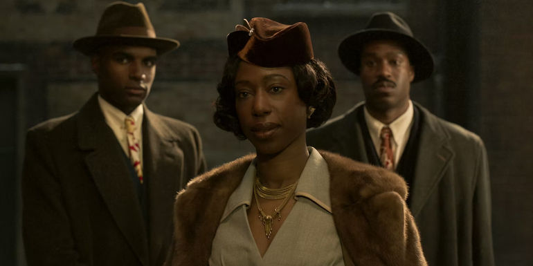 La Fontaine followed by two bodyguards in The Outfit