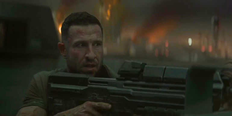 John (Pablo Schreiber) with a Battle Rifle while Reach burns in Halo season 2