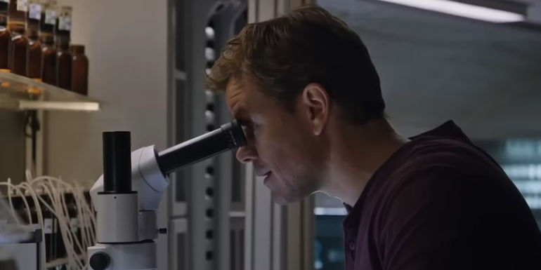 Mark Watney (Matt Damon) looking through a microscope in The Martian.