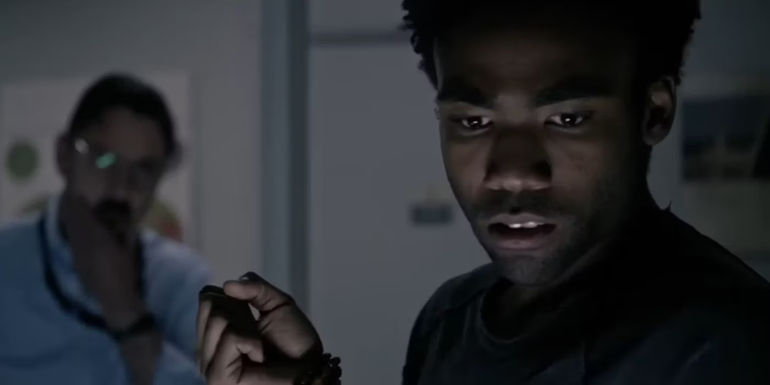 Rich (Donald Glover) staring at something with someone behind him in The Martian.