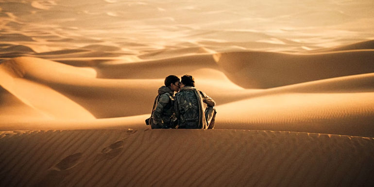 Paul and Chani kiss on top of a sand dune in Dune 2