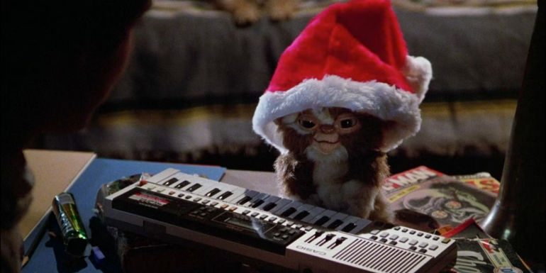 Gizmo in a christmas hat playing a keyboard in Gremlins