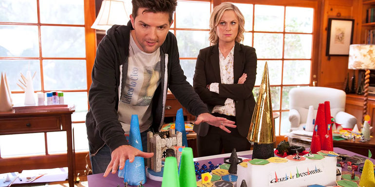 Ben shows Leslie his new game Cones of Dunshire.