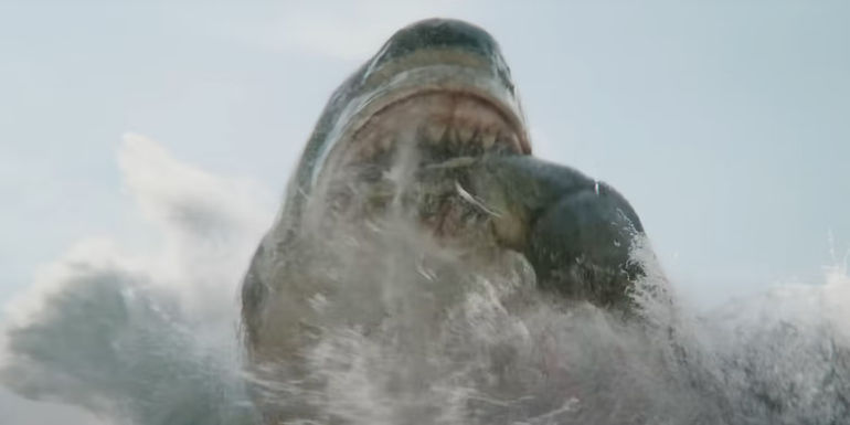 A meg picks up a T rex in Meg 2 The Trench