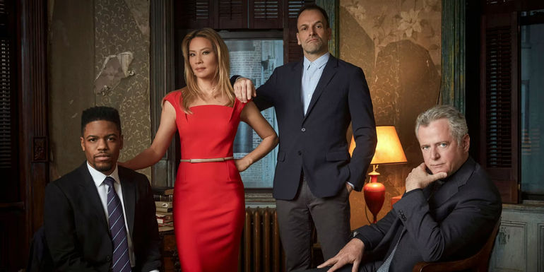 Jon Michael Hill, Lucy Liu, Johnny Lee Miller, and Aidan Quinn posing for Elementary season 7's promo pic