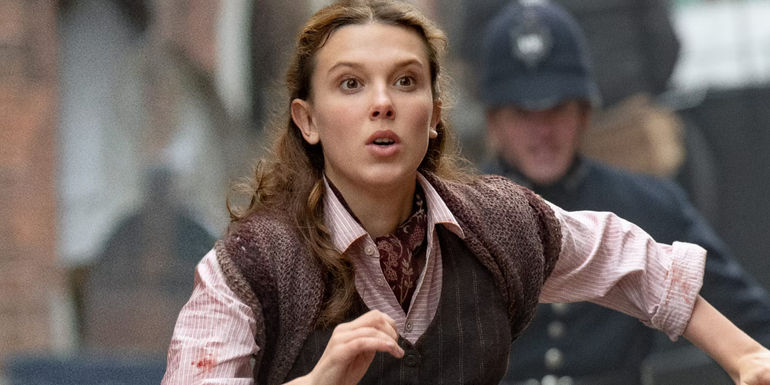 Enola Holmes (Millie Bobby Brown) running from police in Enola Holmes 2.