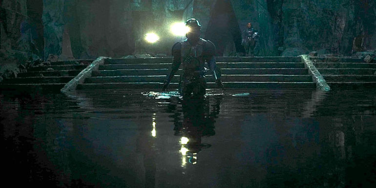 Din Djarin bathes in the Living Waters in the mines of Mandalore in The Mandalorian season 3