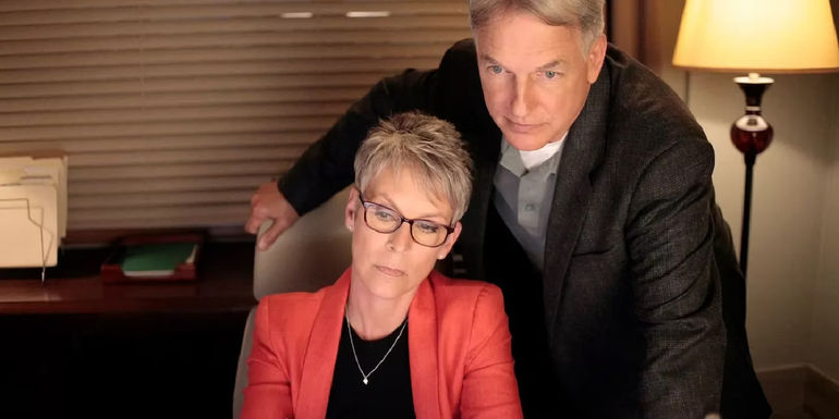 Samantha Ryan looking at a computer while Gibbs stands behind her.