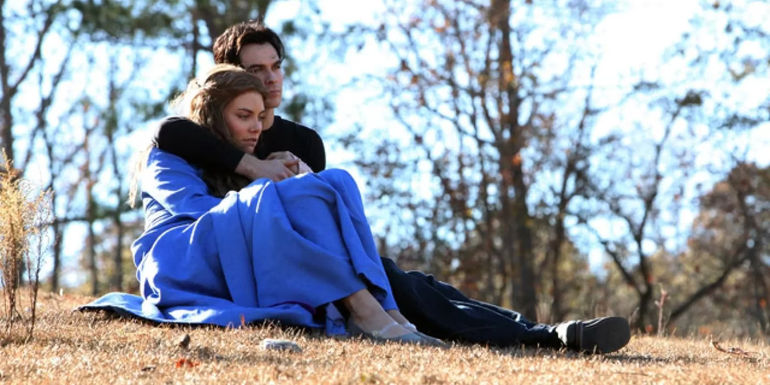 Rose and Damon sitting together outside in a field on The Vampire Diaries