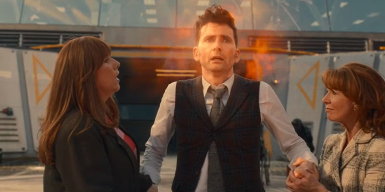 Donna Noble and Mel Bush hold the Fourteenth Doctor's hands as he regenerates