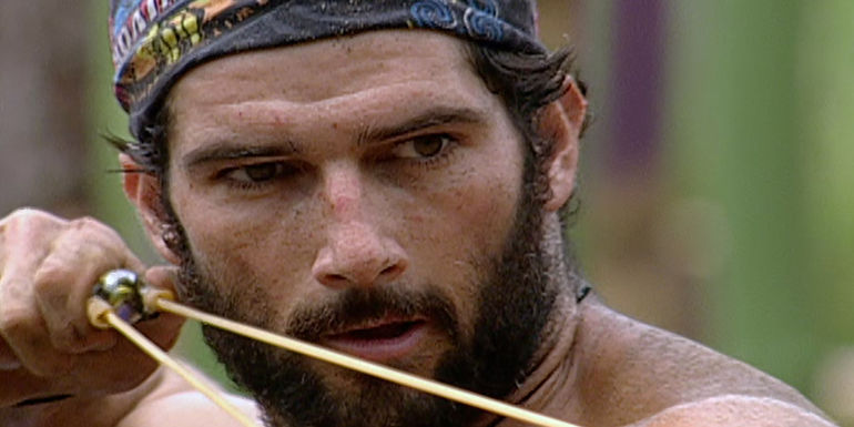 Burton Roberts aims a slingshot during a challenge on Survivor: Pearl Islands