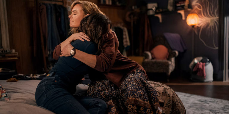 Mae (Madeleine Arthur) and Suzanne (Emily Deschanel) hug on the bed in Devil in Ohio