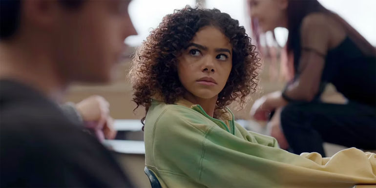 Ginny looks over at her classmate while sitting at a desk in Ginny & Georgia season 2.