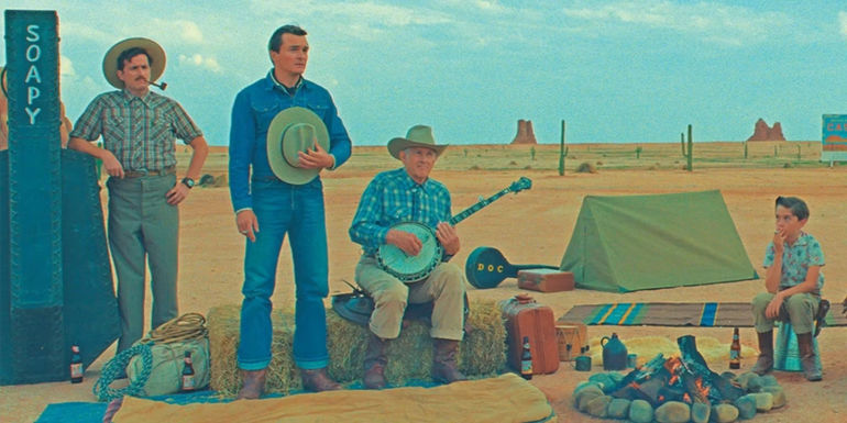 Montana (Rupert Friend) sings a song next to a campfire in Asteroid City