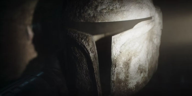 Din shining his light on an abandoned Mandalorian helmet in The Mandalorian Season 3