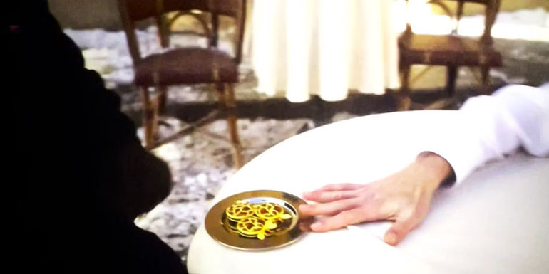 Willy Wonka giving a man giraffe-milk macarons in the Wonka movie