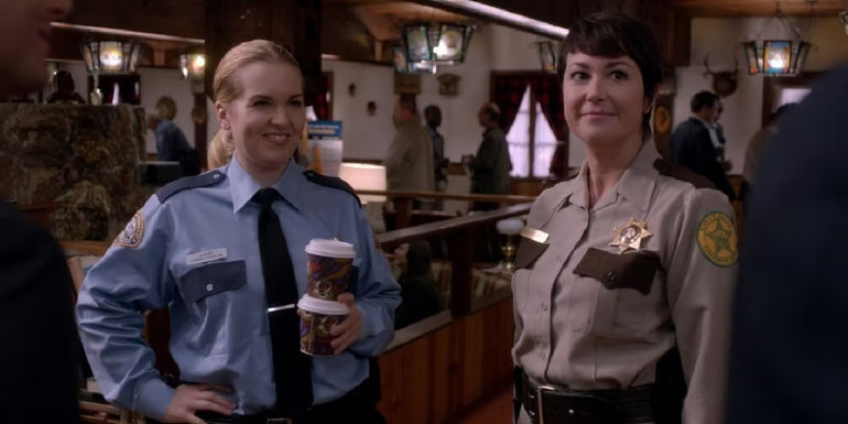Kim Rhodes as Sheriff Jody Mills standing next to a woman holding coffee in Supernatural's 
