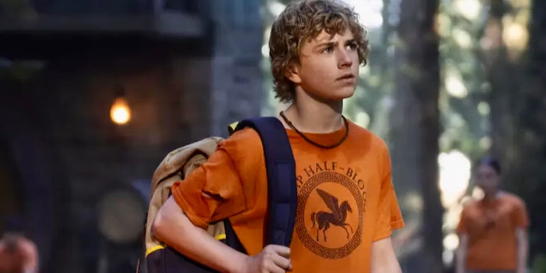 Walker Scobell as Percy with his backpack in Camp Half-Blood in Percy Jackson and the Olympians.