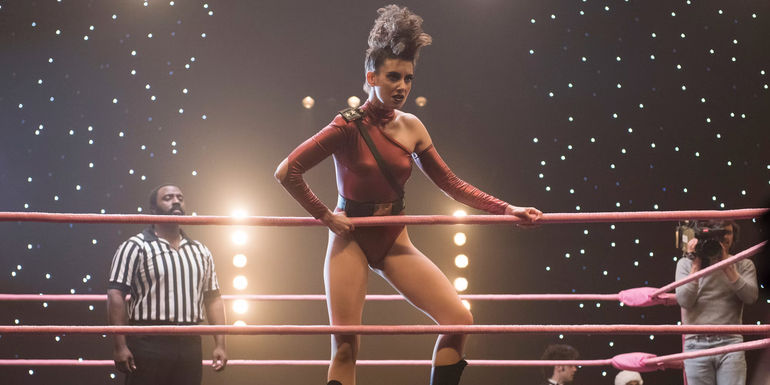 Ruth (Alison Brie) in character as Zoya the Destroya, standing at the corner of a fighting ring and holding the ropes in GLOW