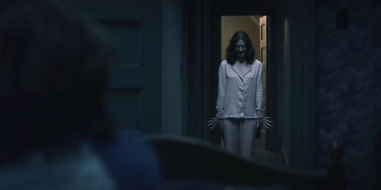 Lizzy Caplan as a mother possessed in a doorway in Cobweb