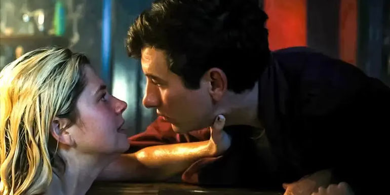 Venetia is in the bathtub and holding Oliver's neck, as their faces are inches apart in Saltburn.