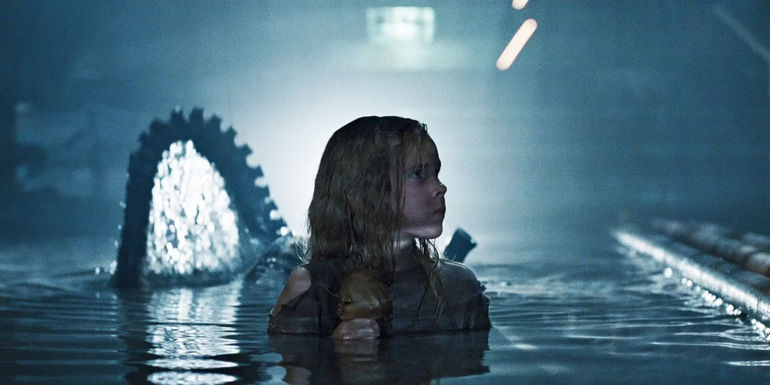 Newt in the water with an alien behind her about to emerge from the water in Aliens