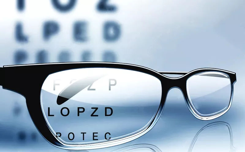 Eyeglasses in front of an eye chart during a vision test