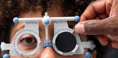 Patient undergoing a comprehensive eye exam with a phoropter