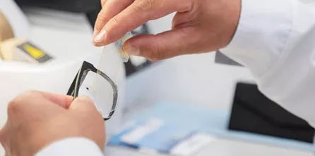 Hands repairing an eyeglass frame and lens