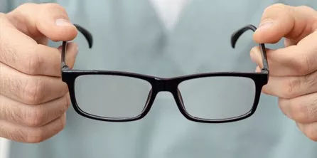 Hands holding a pair of eyeglass frames for frame styling