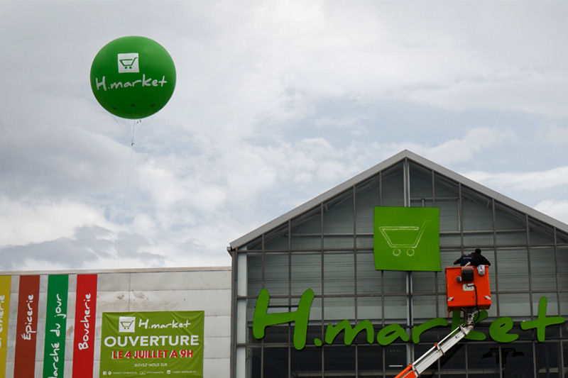 ballon helium vert 250cm devant un magasin hmarket